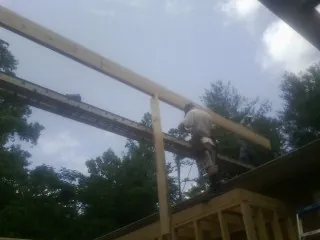 Carpenter setting a ridge beam over a new addition frame — Ice Dam Removal by Roofing Brothers in North Oxford