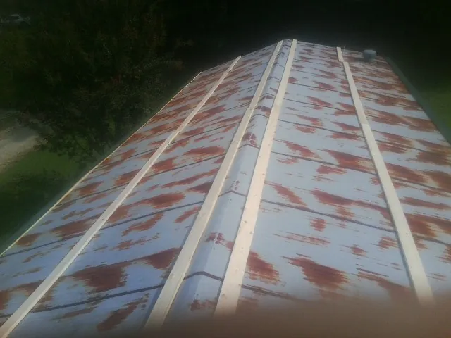 Rusted metal roof panels with new wood purlins before replacement — Storm Damage Roof Repair in North Oxford by Roofing Brothers