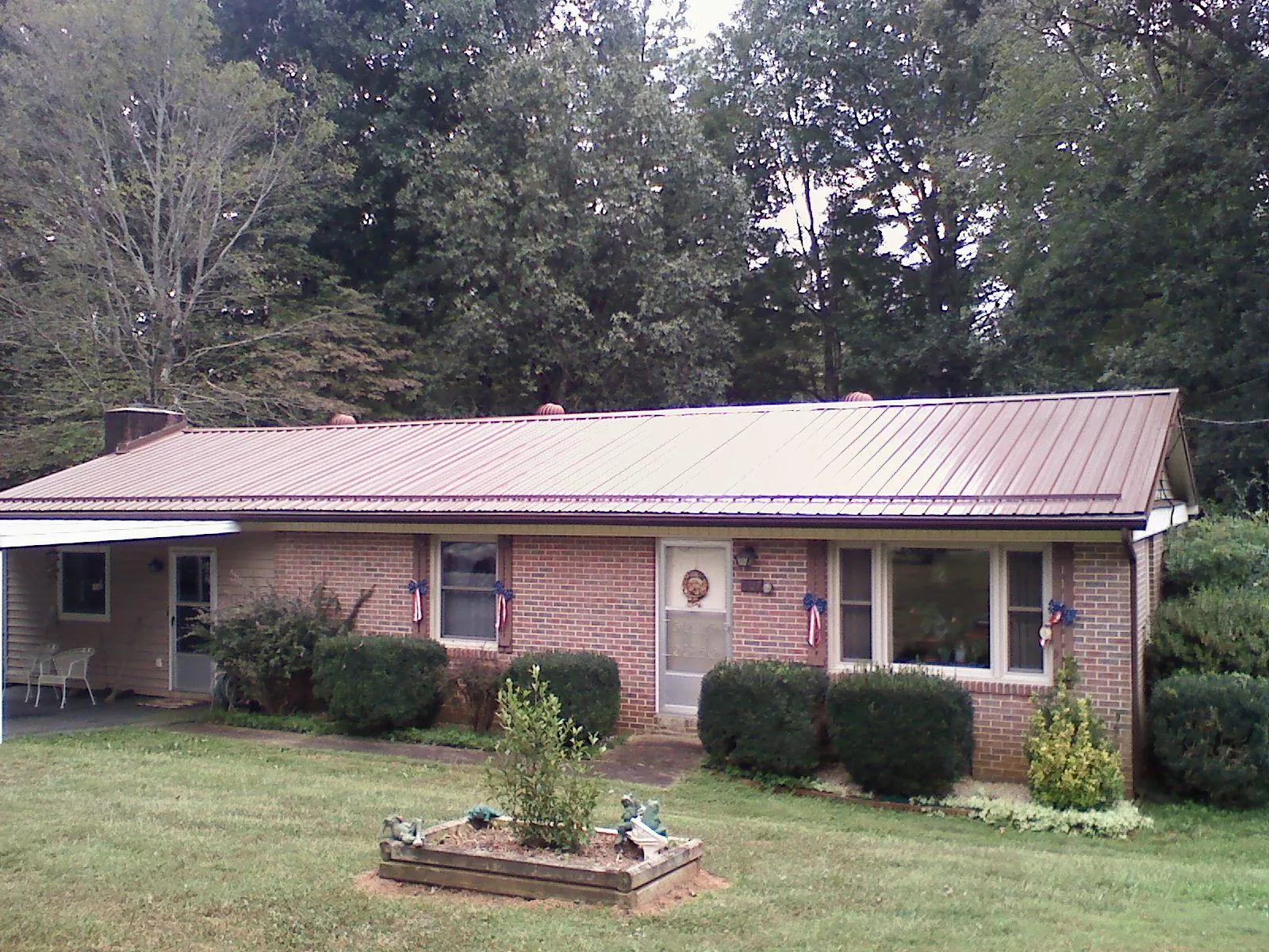 Bronze metal roof on a brick ranch home with a carport in North Oxford