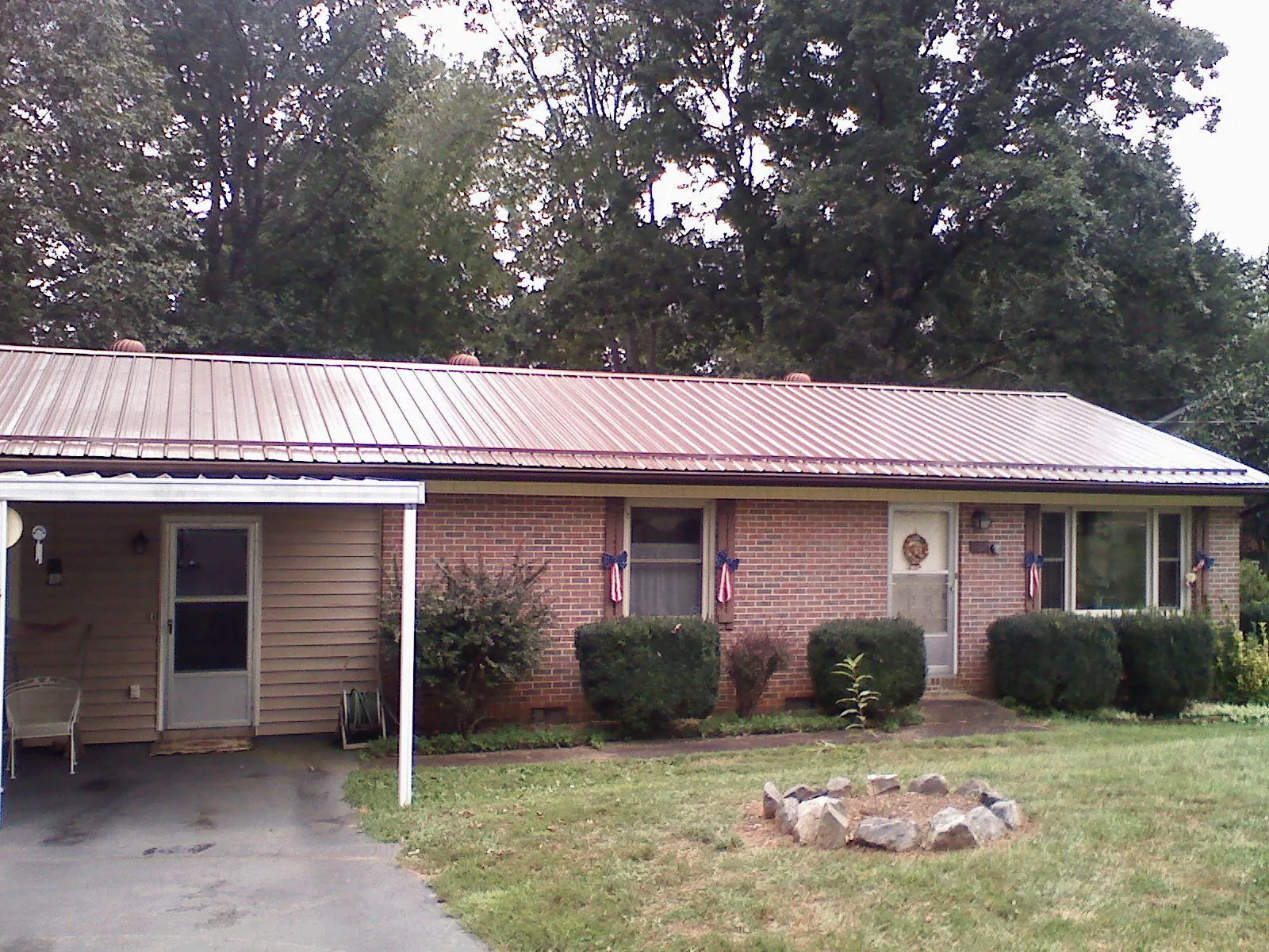 Bronze metal roof and carport on a brick ranch home — Roof Repair work by our crew in North Oxford